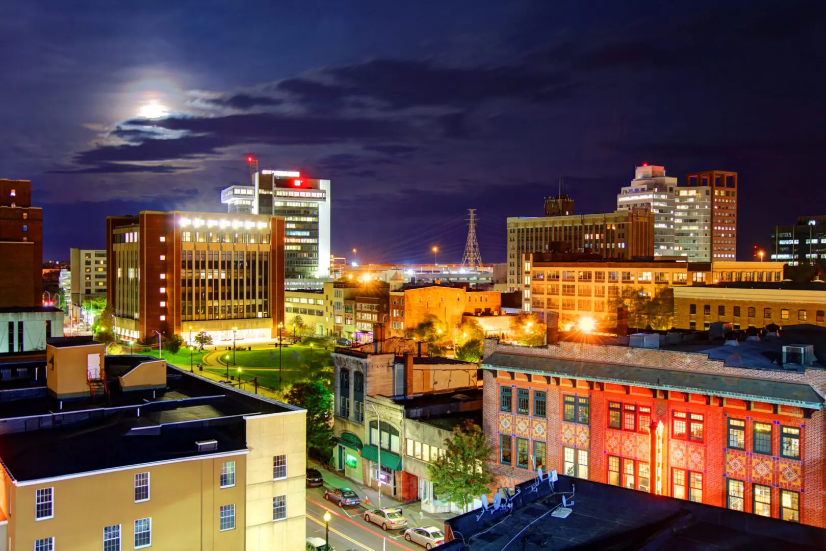 City skyline at night with illuminated buildings.
