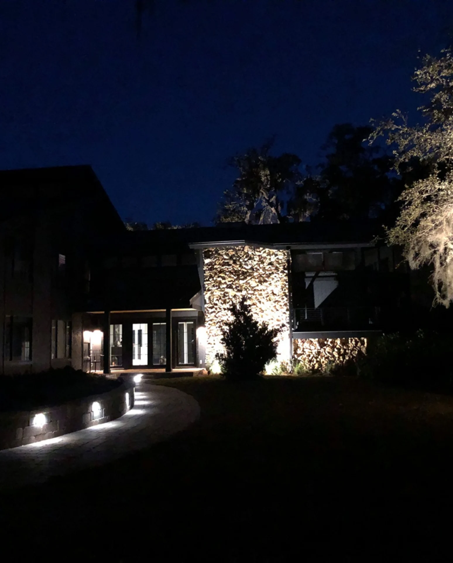 Modern house exterior illuminated at night.