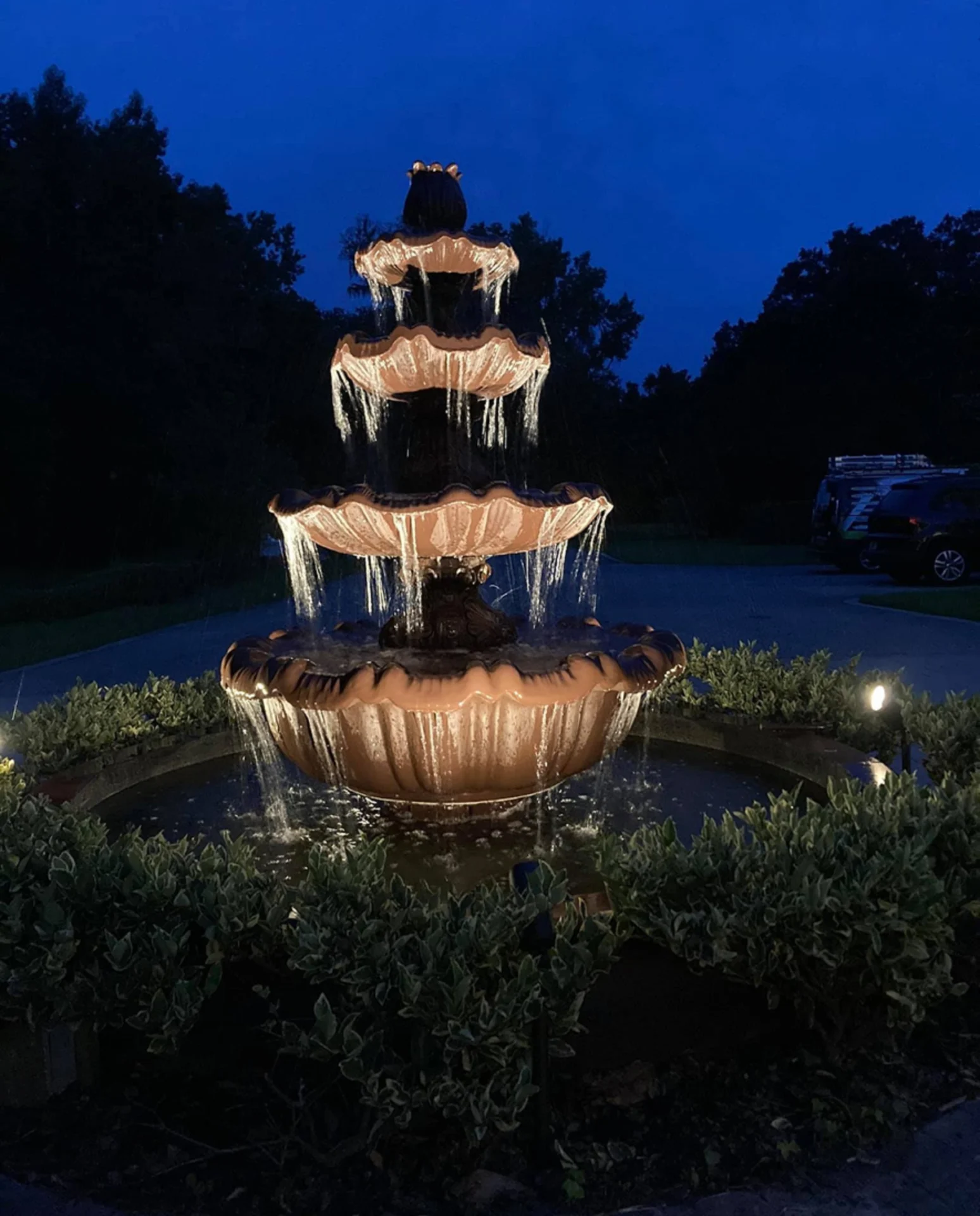 Illuminated tiered fountain at night.
